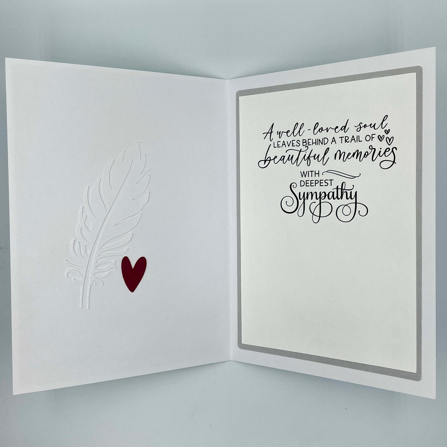 Sympathy card with text and heart design on a gray background