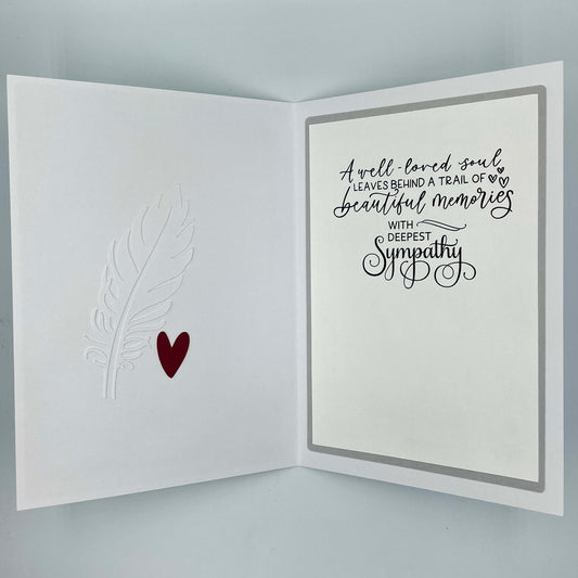 Sympathy card with text and heart design on a gray background