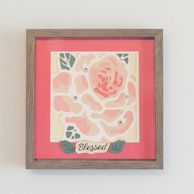 Shadowbox with a framed pink rose design and 'Blessed' text on a red background.