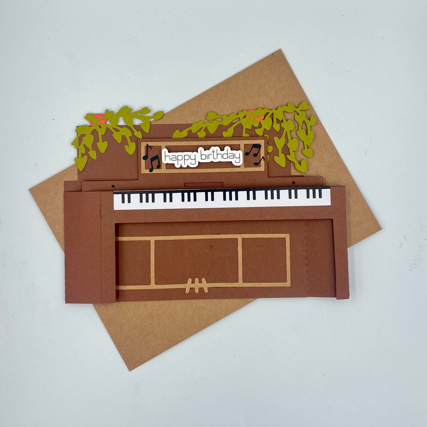 Piano-shaped birthday card with 'happy birthday' text on a white background