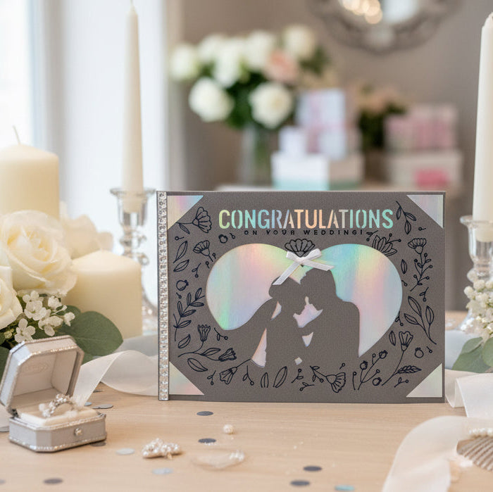 Wedding card with 'Congratulations' on a table with flowers and candles