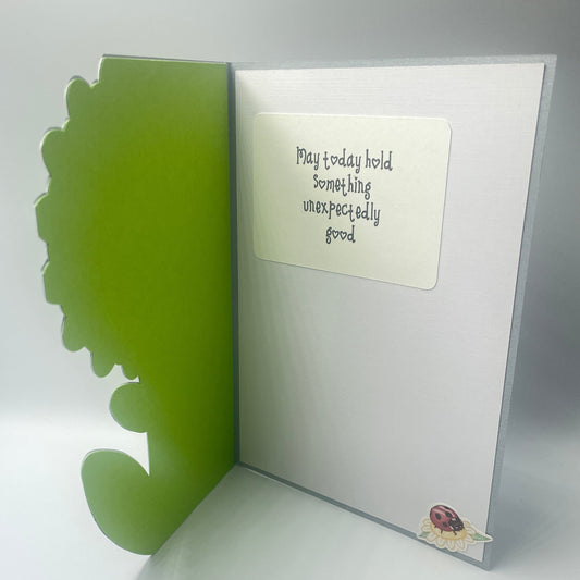 Open greeting card with text and a green leaf design on a white background