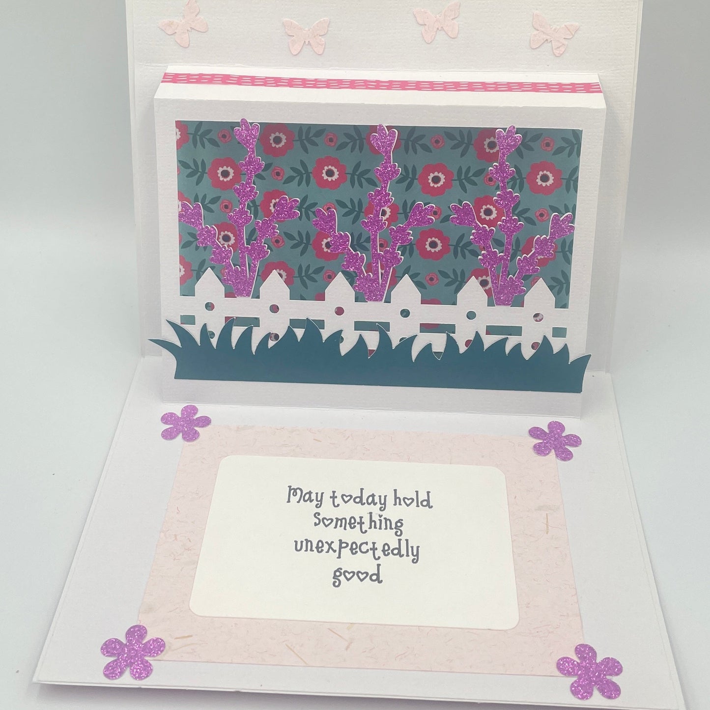 Open card with floral design and text on a gray background