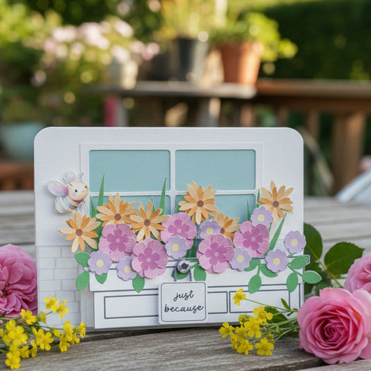 Decorative card with flowers and a small sign on a wooden surface with pink roses and yellow flowers.
