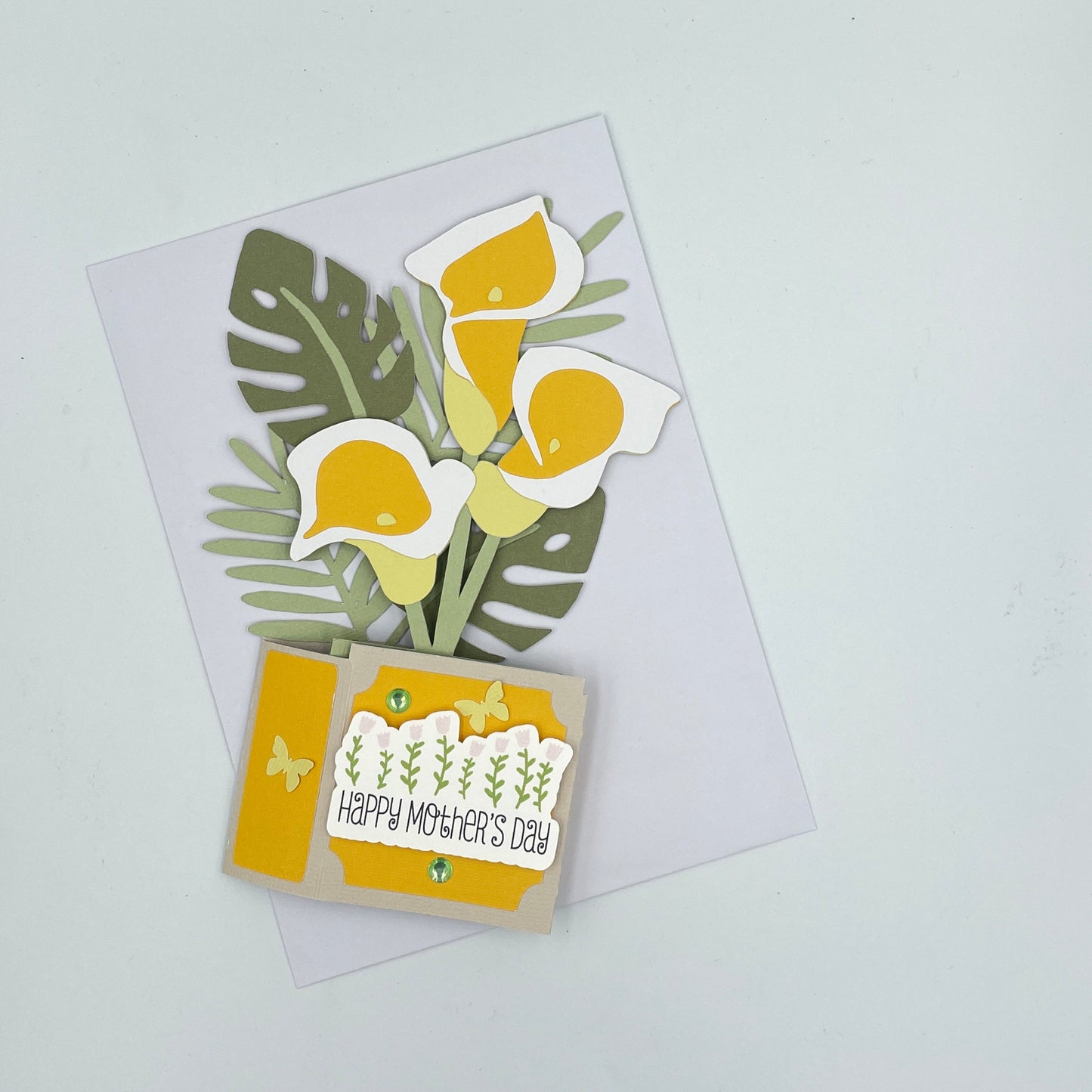 Flattened yellow lilies box card on a white envelope