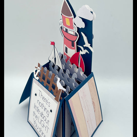 Pop-up card with a lighthouse design on a white background