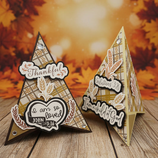 Two pyramid shaped cards with layered cardstock details, featuring autumn wheat motifs and scriptural text, displayed on a fall background.