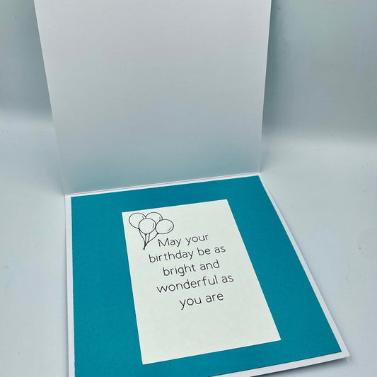 Greeting card with birthday message and balloons on a teal background