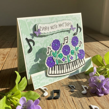 Card with musical notes and flowers on a wooden surface with flowers and music notes around