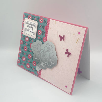 Greeting card with floral patterns and butterfly designs on a light gray background