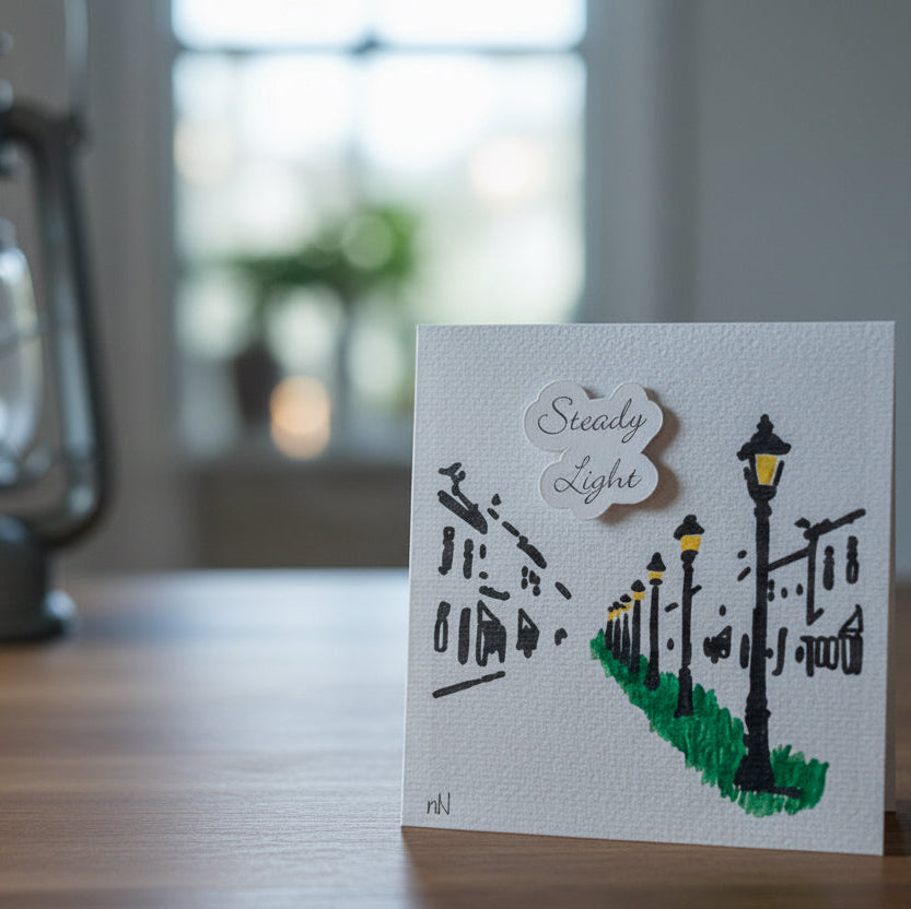 Card with street lamp design and lantern on a table
