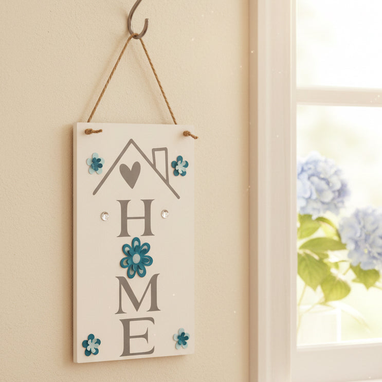 Decorative sign with 'HOME' and floral designs hanging on a wall.