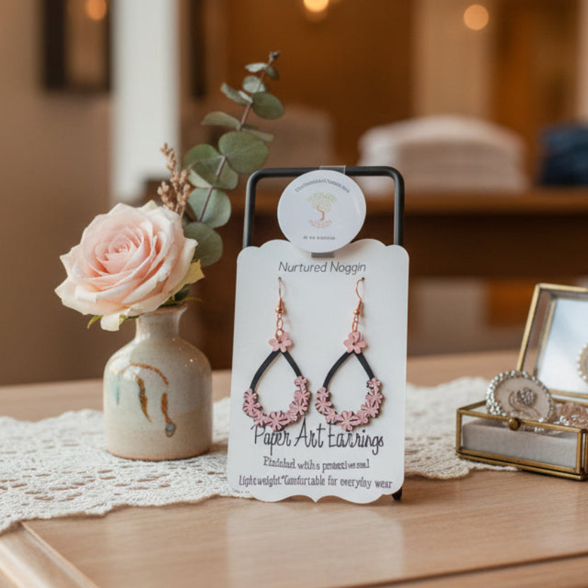 Pair of earrings on a branded card with a gray background