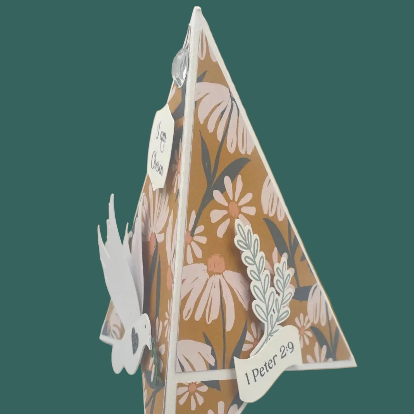 Decorative paper cutout with floral patterns and text on a green background