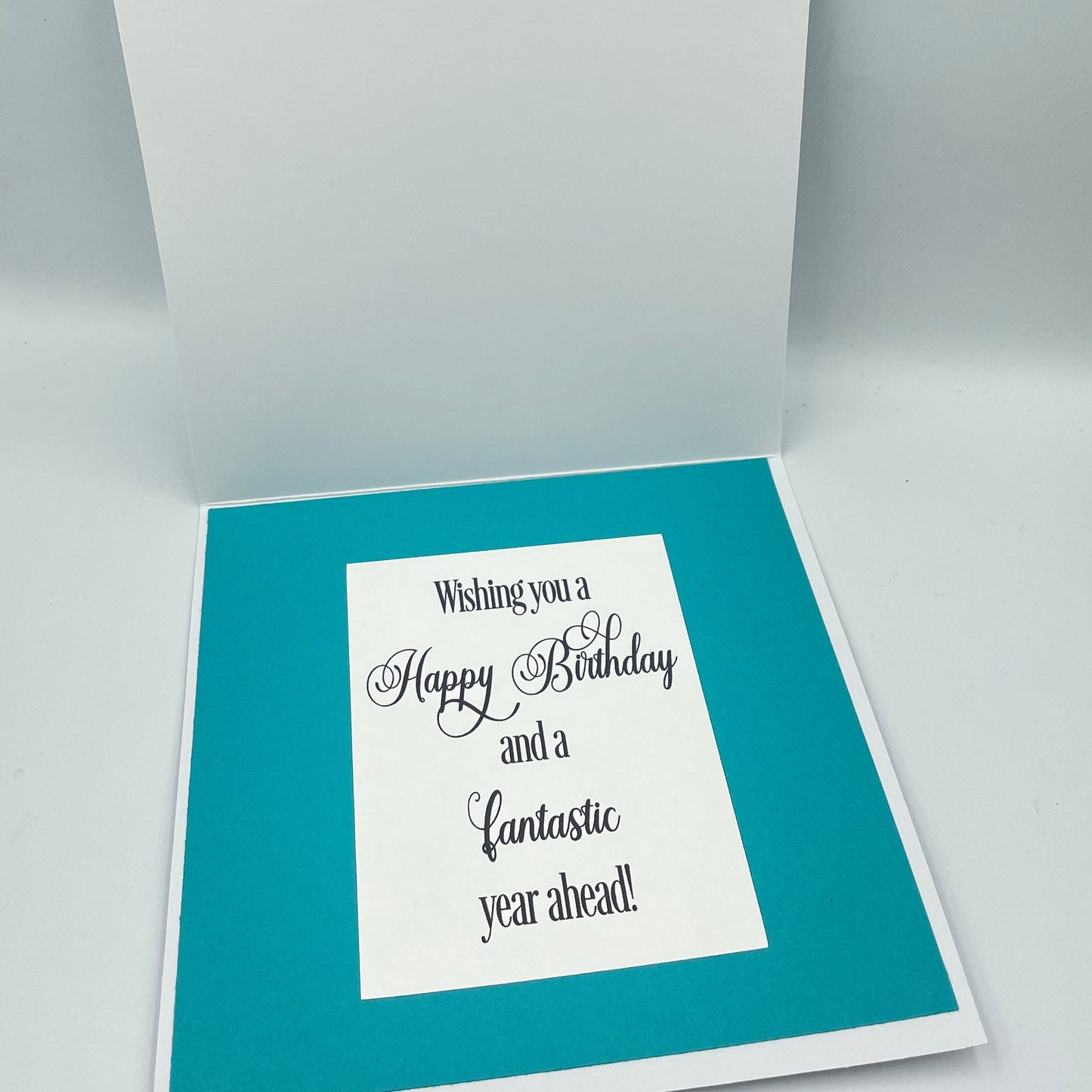 Greeting card with blue interior and white text on a gray background