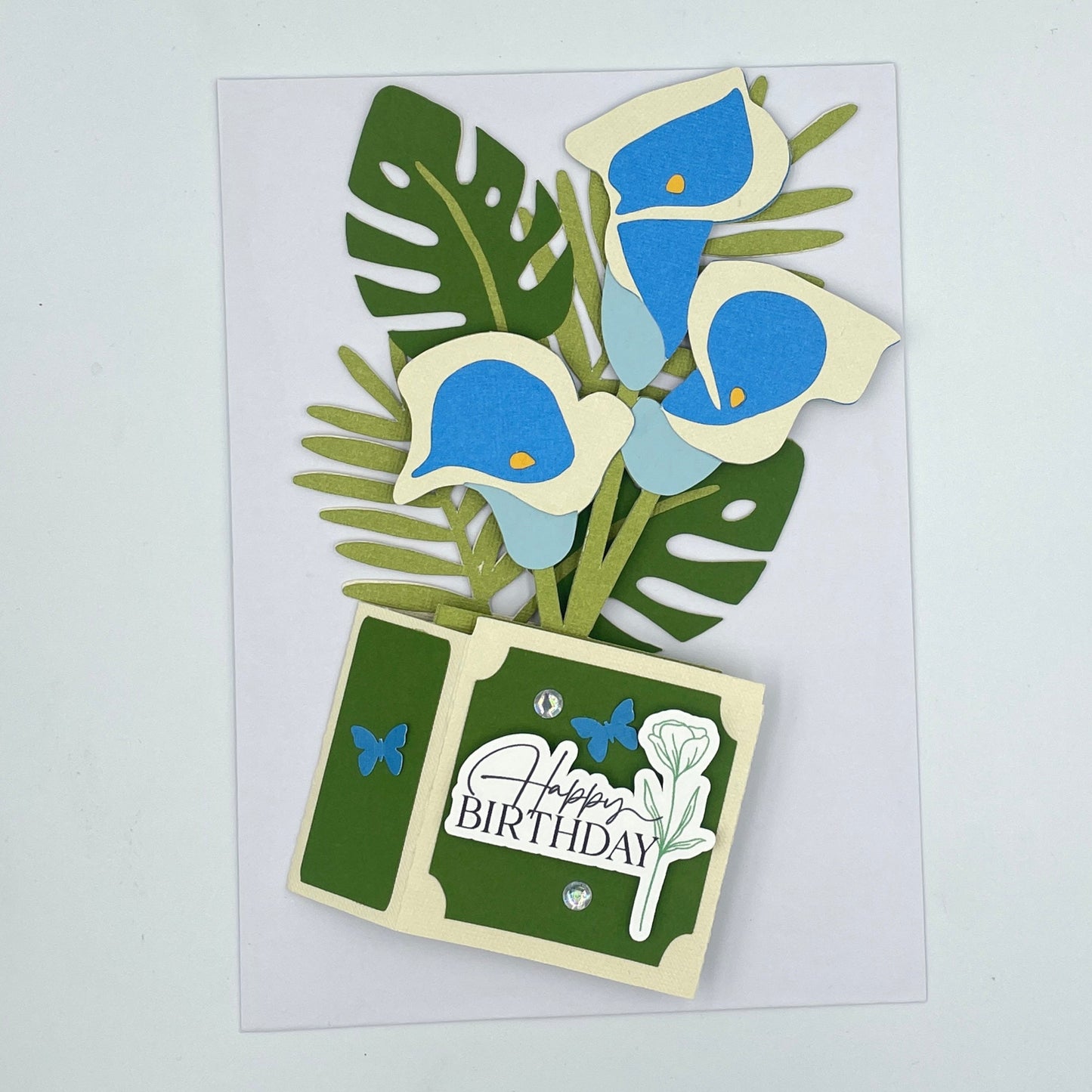 Flattened blue lilies box card on a white envelope