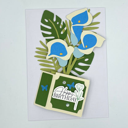 Flattened blue lilies box card on a white envelope
