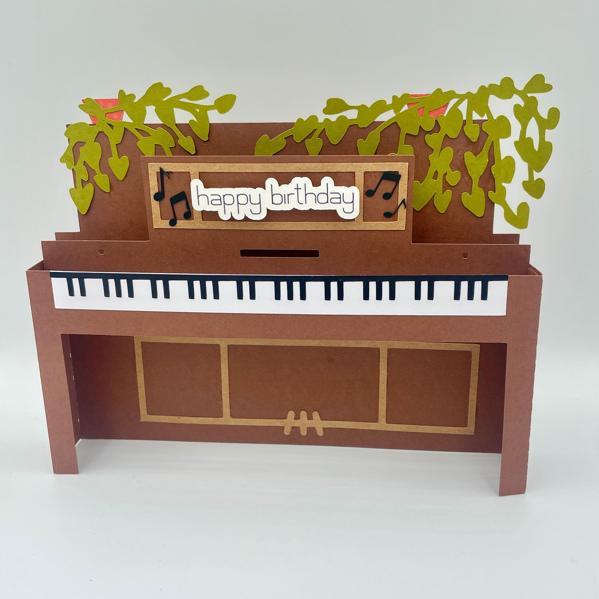 Piano-shaped birthday card with 'happy birthday' message and musical notes on a white background
