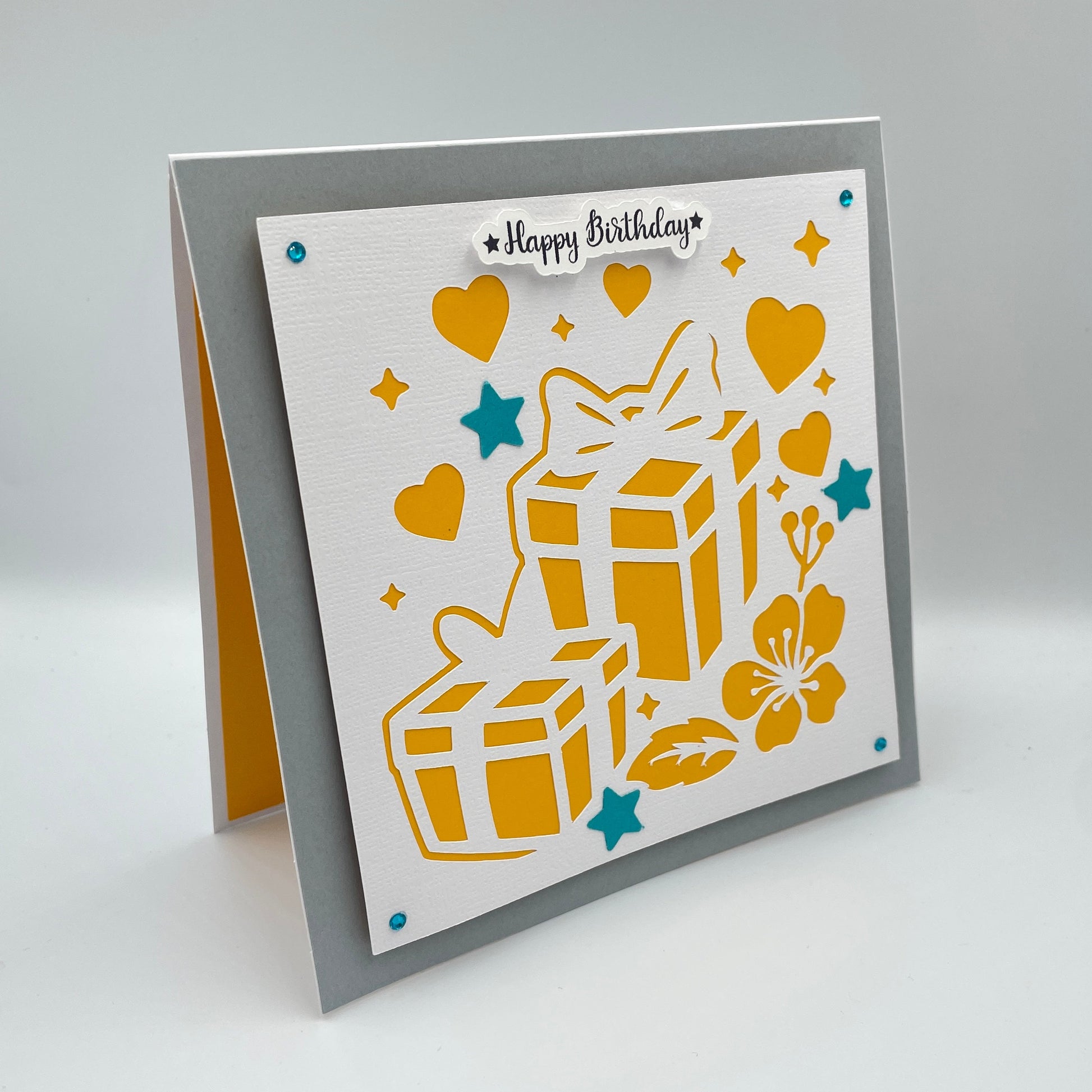 Greeting card with yellow gift boxes, hearts, and flowers on a gray background