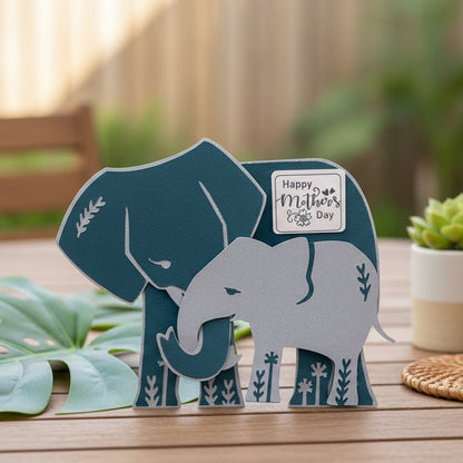 Two elephants with a 'Happy Mother's Day' card on a light gray background