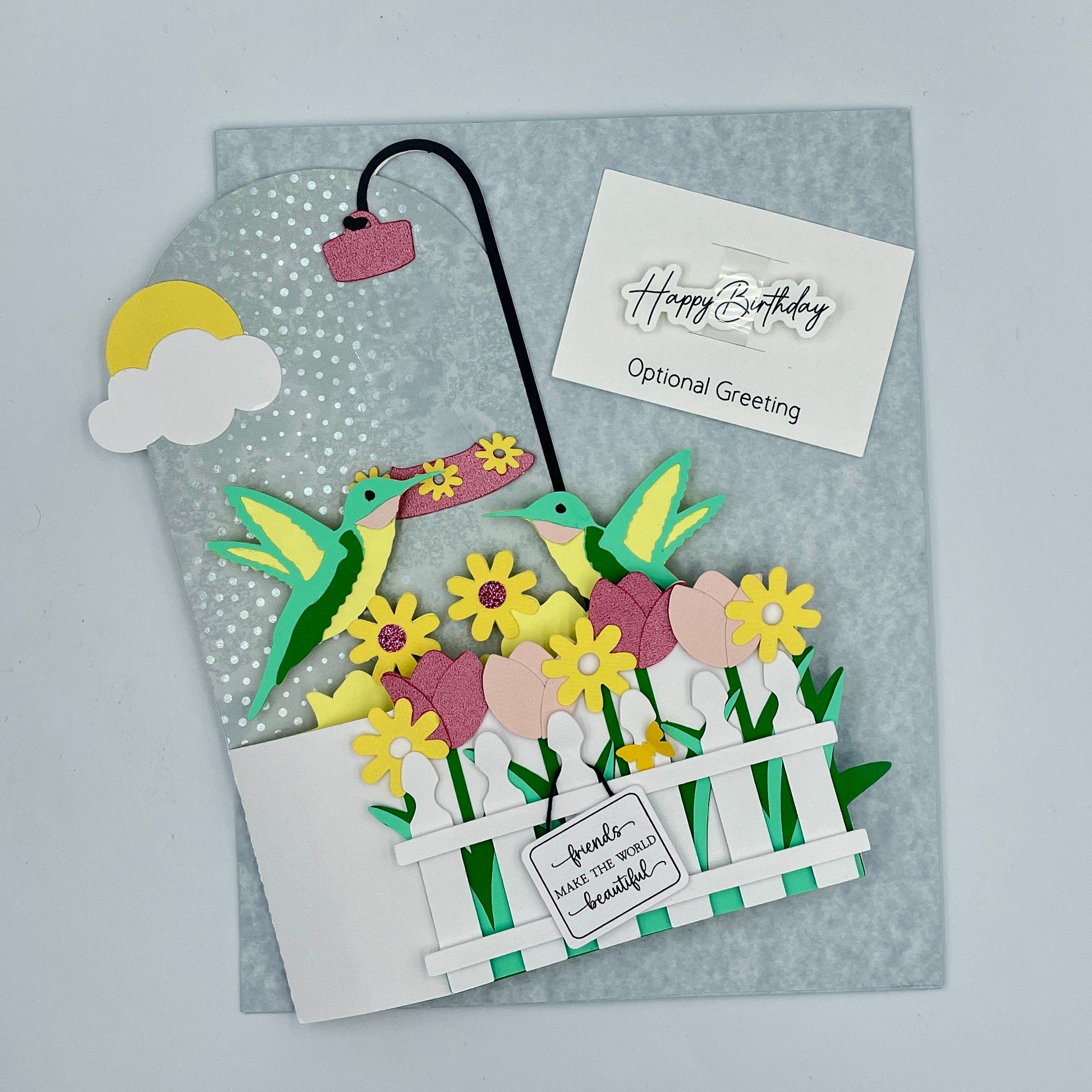 Greeting card with colorful flowers, birds, and a fence on a gray background