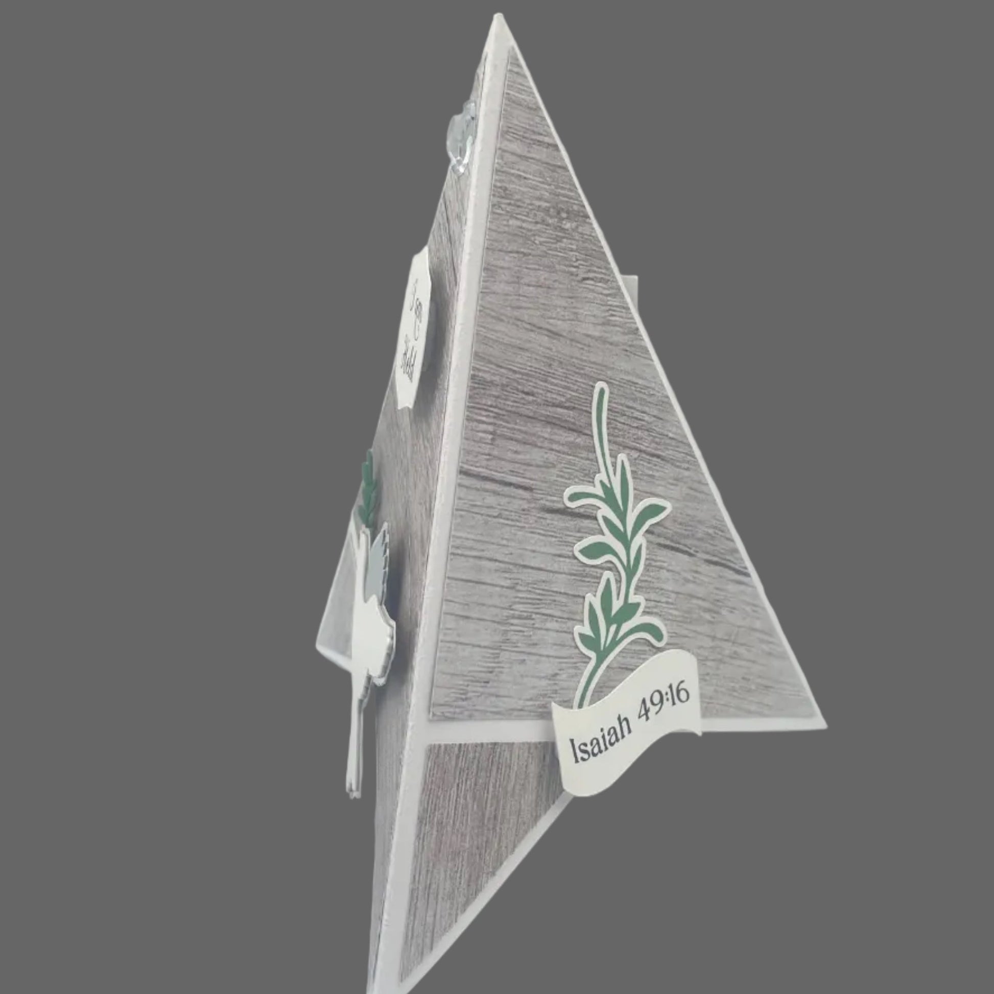 Decorative triangle with a plant design and 'Isaiah 9:16' text on a gray background