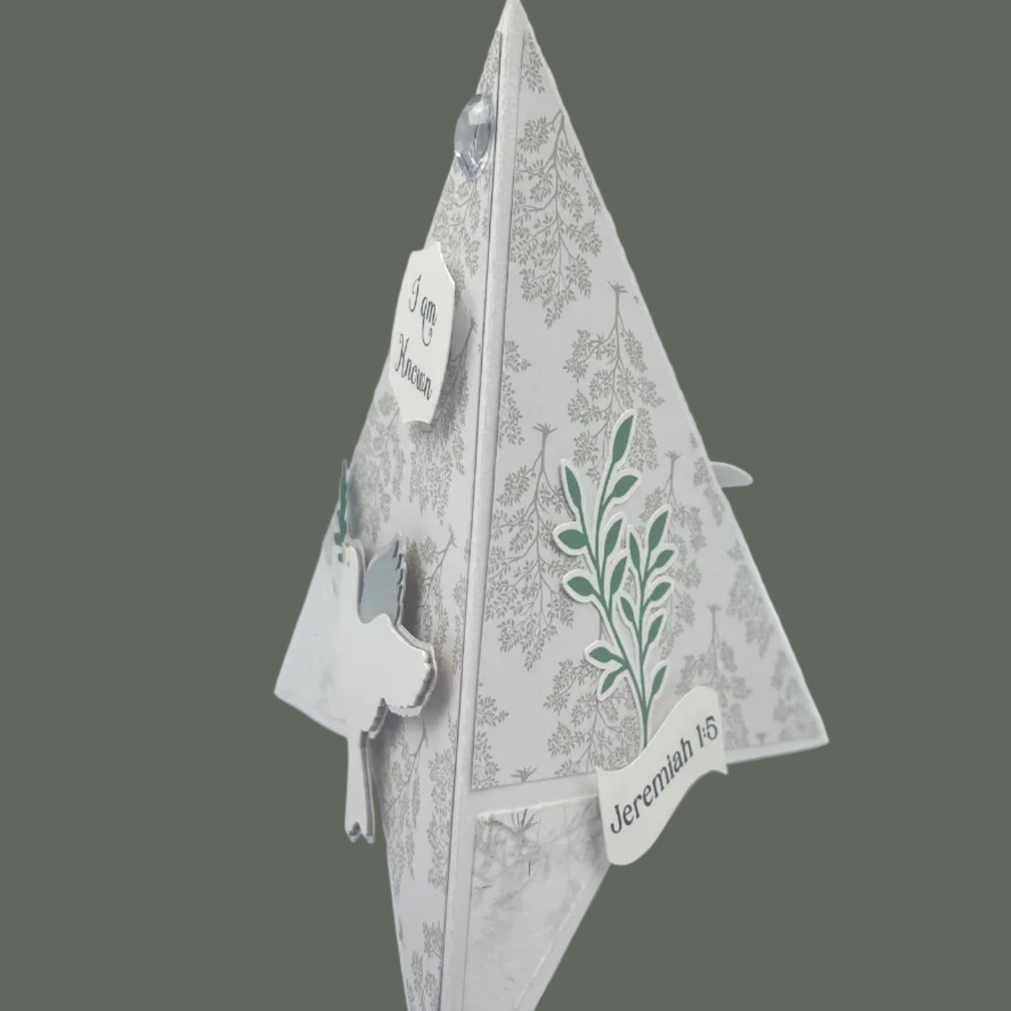 Decorative paper cutout of a leaf design on a gray background