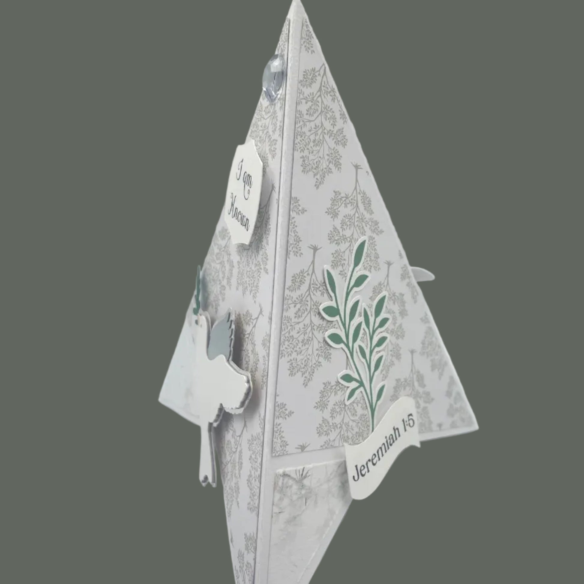 Decorative paper cutout of a leaf design on a gray background
