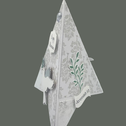 Decorative paper cutout of a leaf design on a gray background