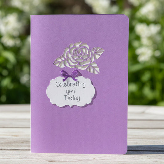 Purple notebook with white floral design and text on a light gray background