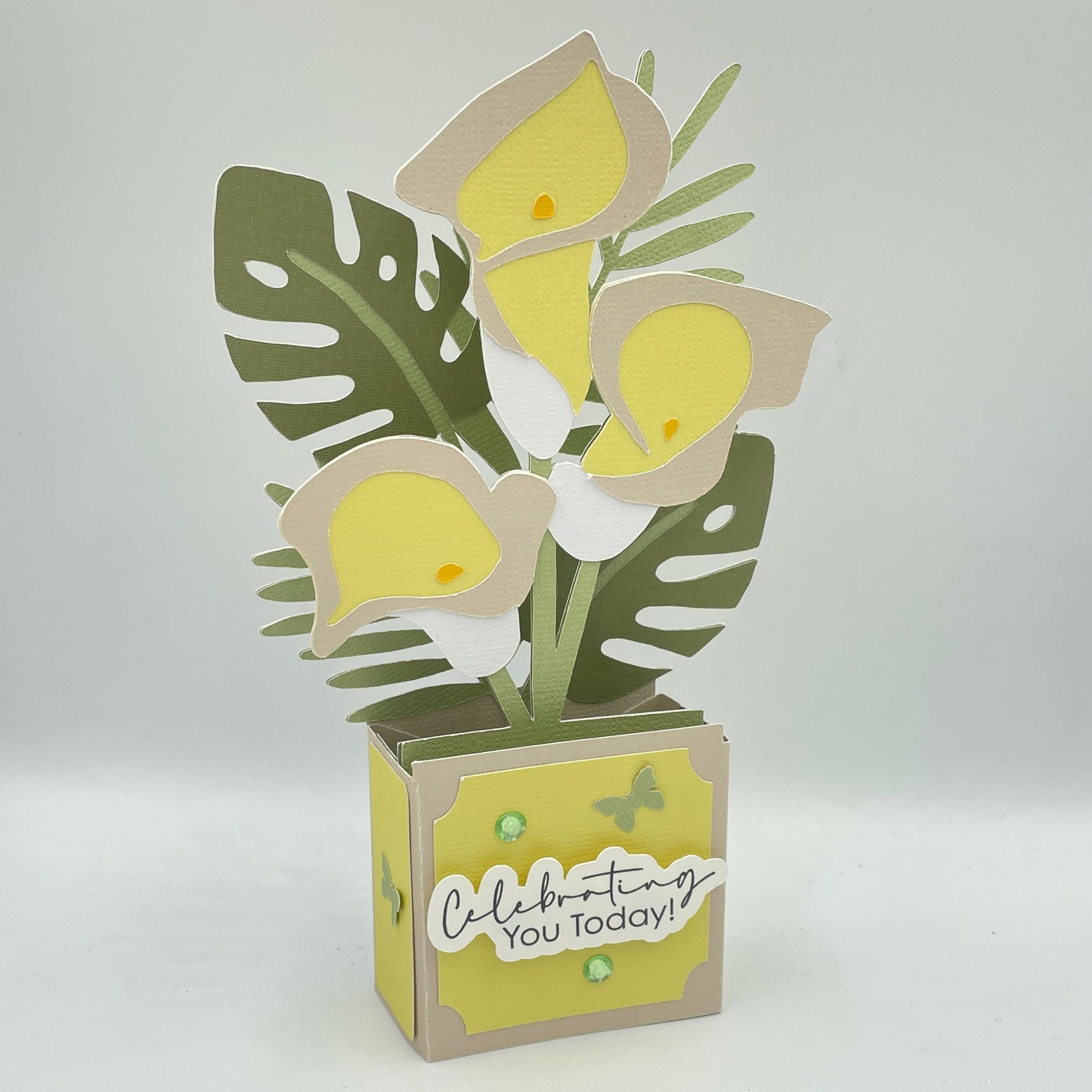 Decorative box card with lilies and leaf design on a white background