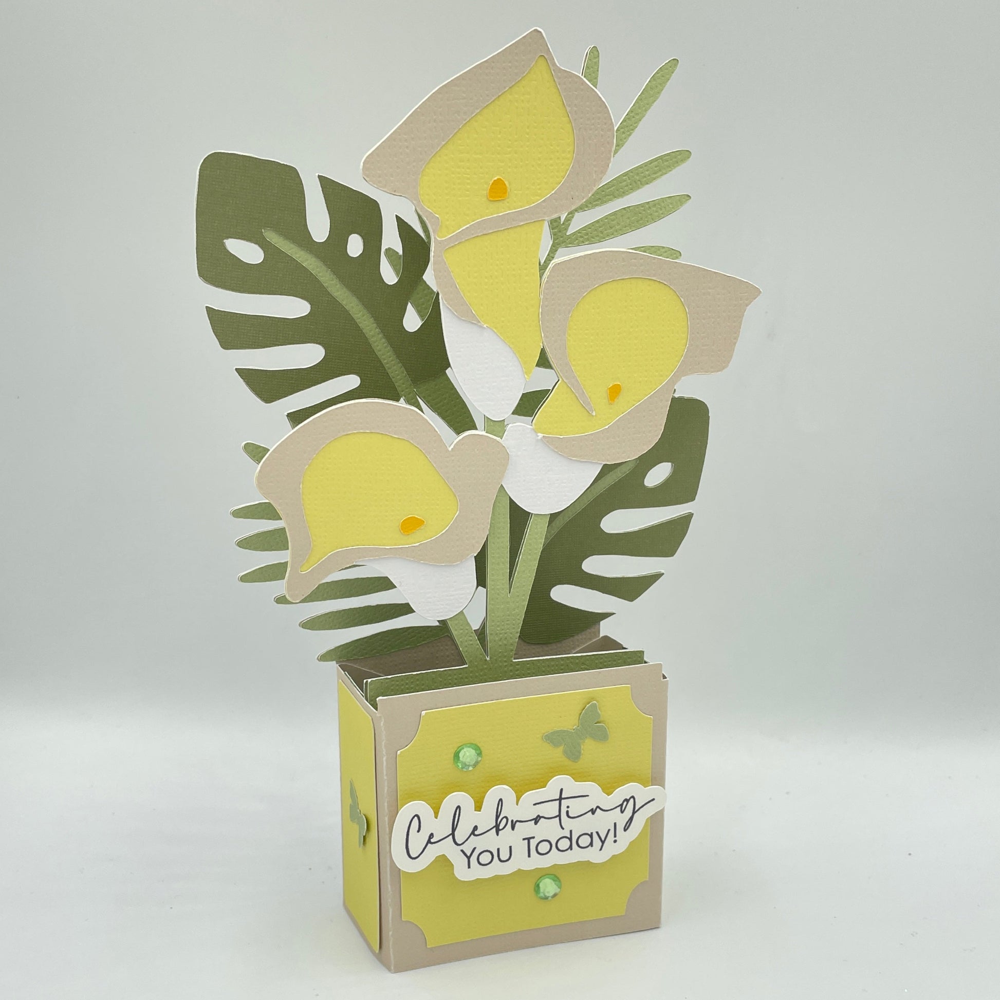 Decorative box card with lilies and leaf design on a white background