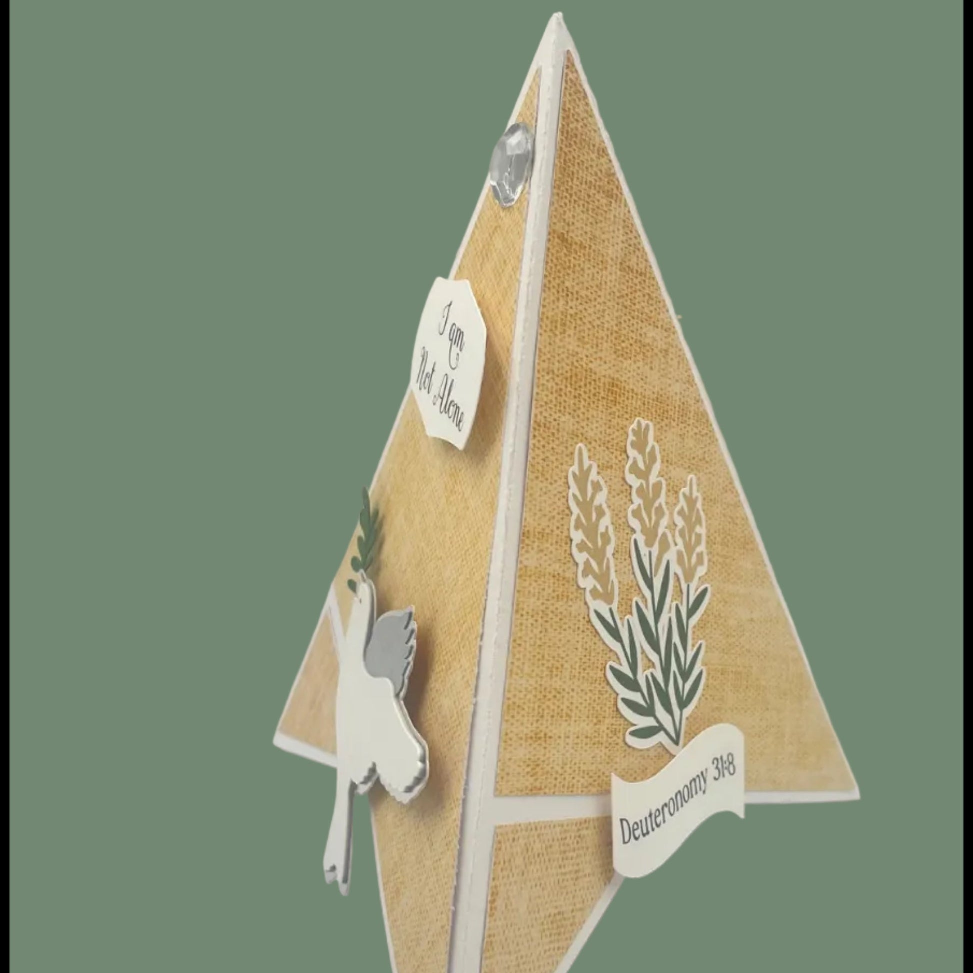 Decorative pyramid card with cut-out elements on a green background