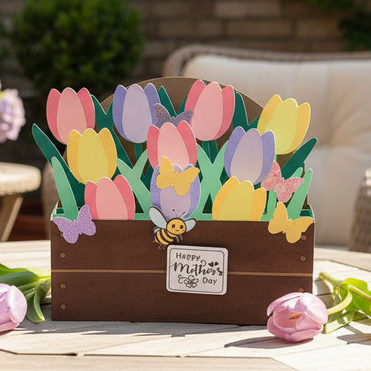 Card with tulips and a bee on a table outdoors