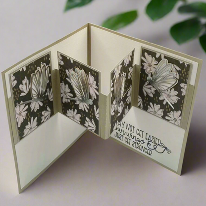 Image of a card with dragonflies. Gray and white shades of color with silver outlines on the dragonflies. 