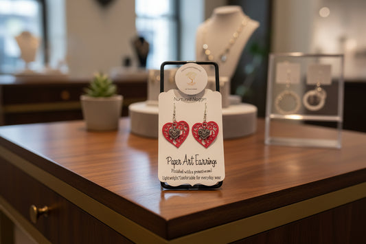 Heart-shaped earrings on a branded card with a gray background