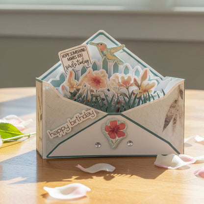 Greeting card with floral design and 'happy birthday' text on a wooden surface.