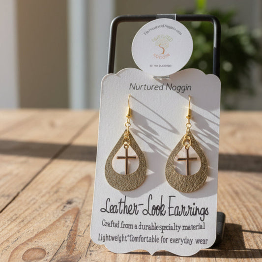 Gold leather look earrings on a branded card displayed on a wooden surface.