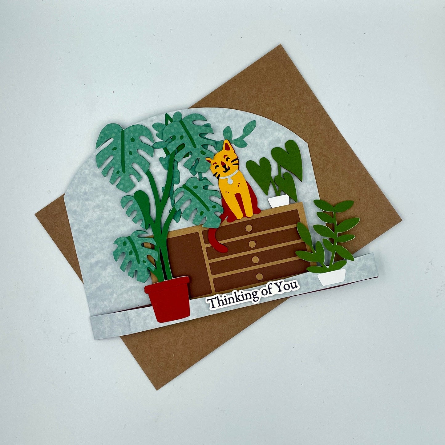 Greeting card with a cat and plants design on a brown envelope